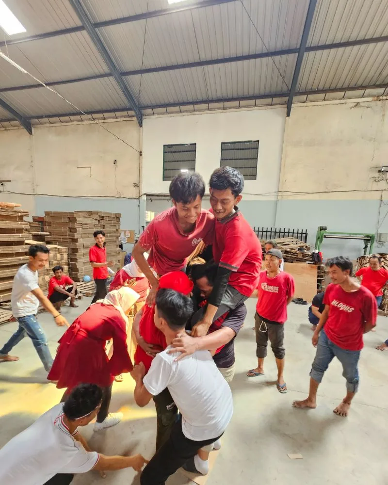 Lomba beregu penuh semangat antar tim JMP di gudang di antara tumpukan karton.