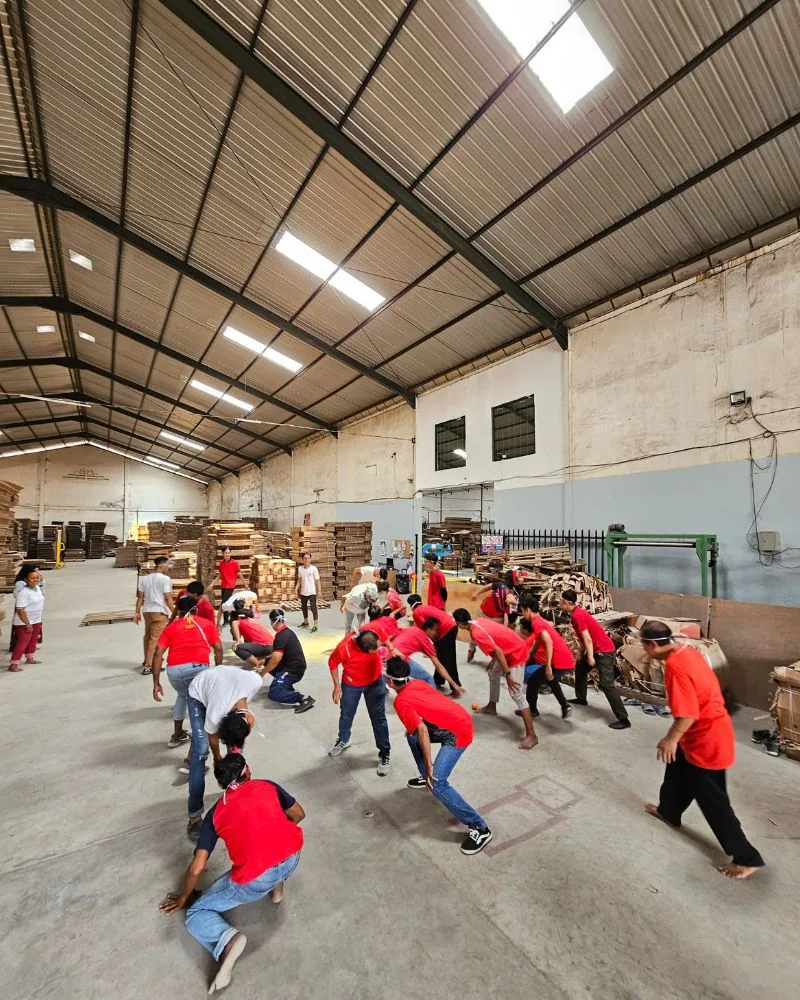 Karyawan JMP berbaju merah bermain lomba kemerdekaan di lantai produksi.