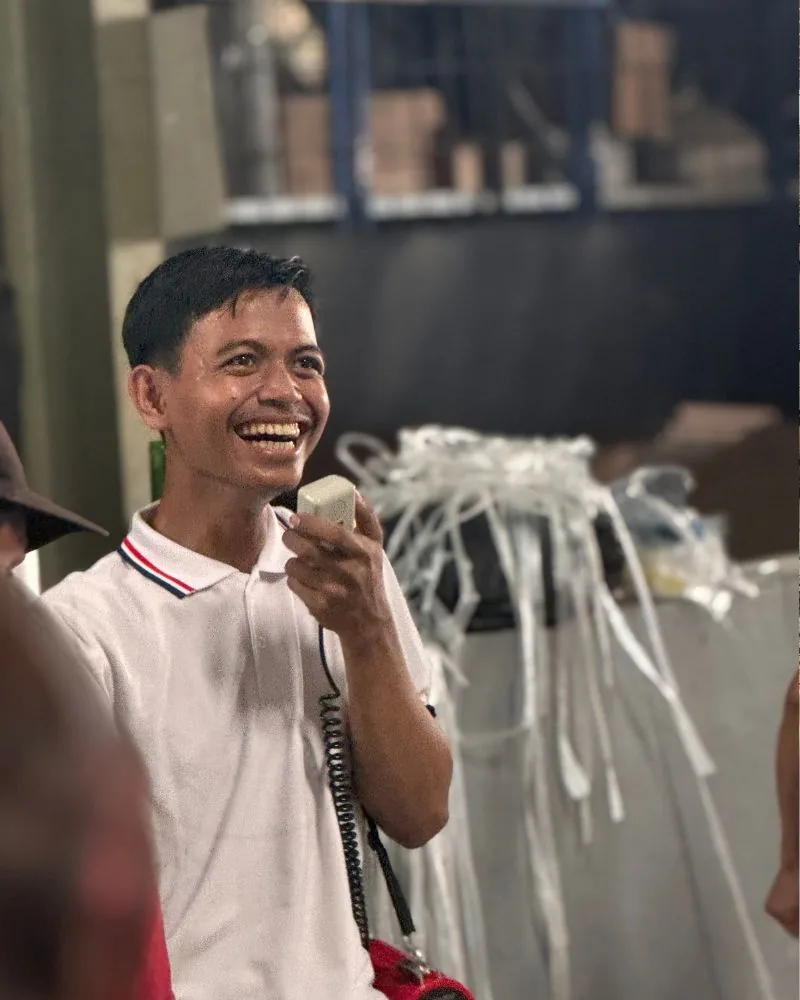 Karyawan JMP membawakan acara sambil tertawa saat malam perayaan 17 Agustusan di pabrik.