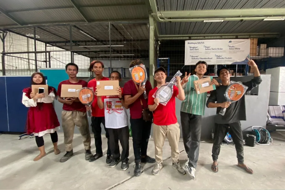 Para pemenang lomba 17-an JMP memegang hadiah — raket dan bingkisan — di depan spanduk Budaya 5R/5S.