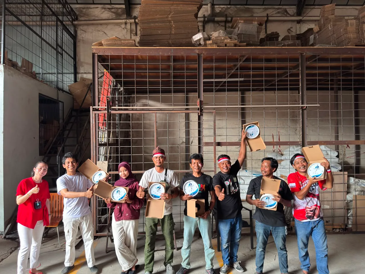 Juara 2 estafet gelas membuka kotak karton berisi jam dinding berlogo JMP.