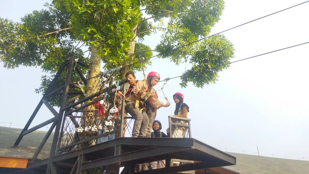 Peserta menjajal wahana tali dan rintangan di ketinggian bersama anak-anak.