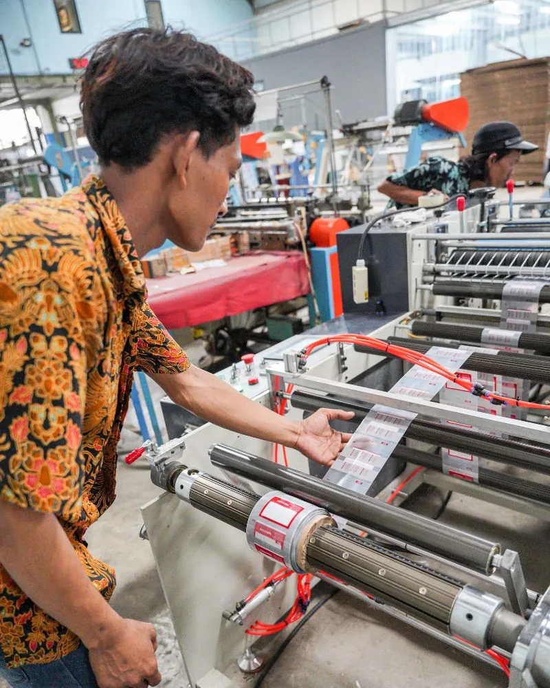 Operator JMP menjalankan mesin pre-opened roll bag untuk lini autobag pelanggan otomotif.
