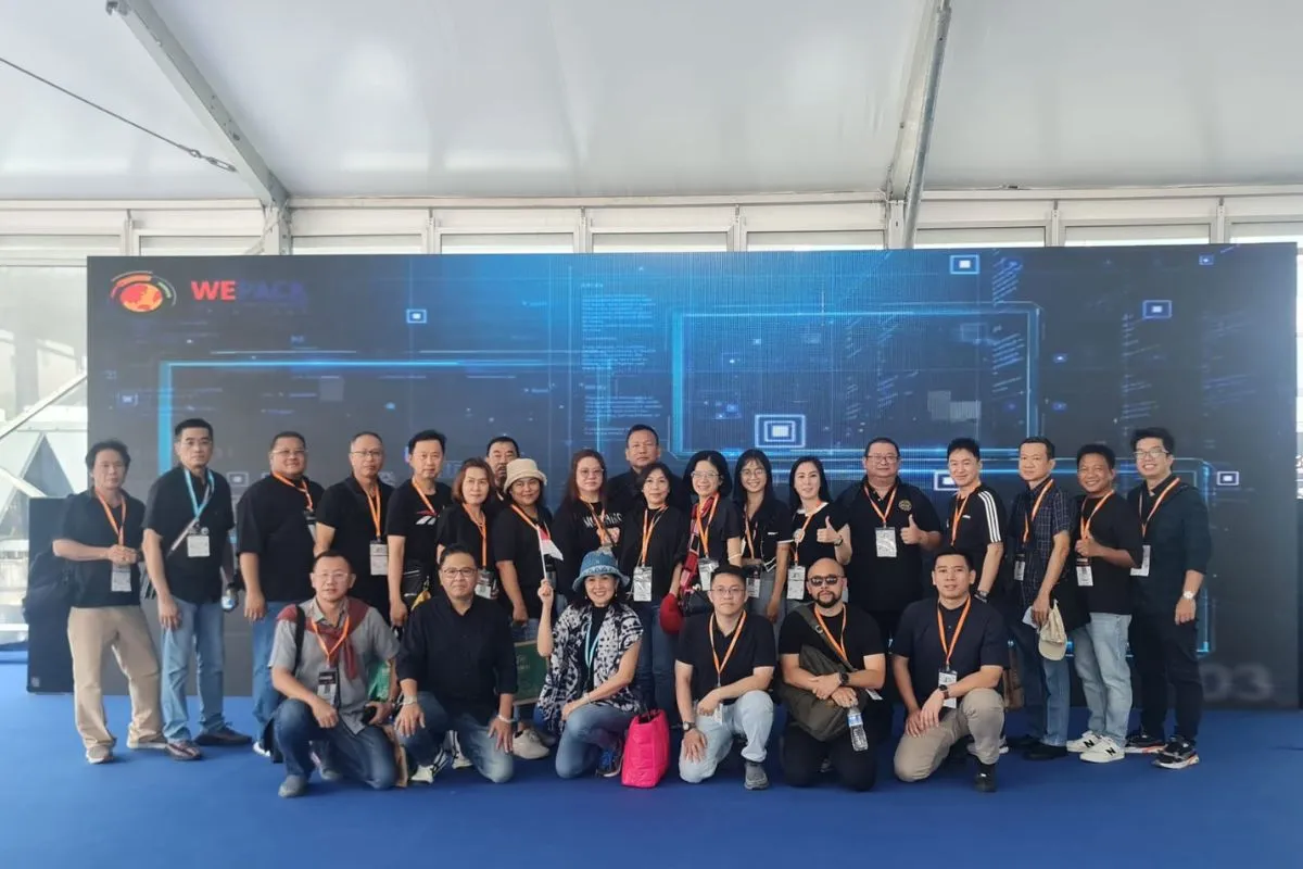 The ACCI delegation photographed in front of the WePack 2023 LED wall, one member holding a small Indonesian flag.